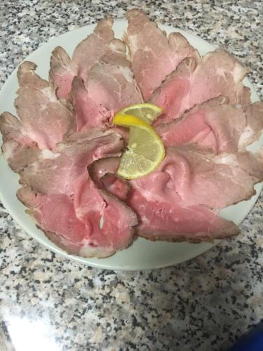 a plate of ham with a slice of lime on it at da Lilia in Salute&Bellezza in Monfalcone