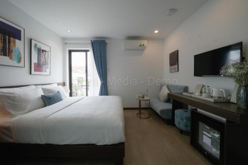 a bedroom with a bed and a tv and a couch at Lion King Hotel in Hoi An
