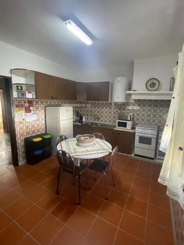 a kitchen with a table and chairs and a refrigerator at Monte de Stª Margarida II in Montemor-o-Novo