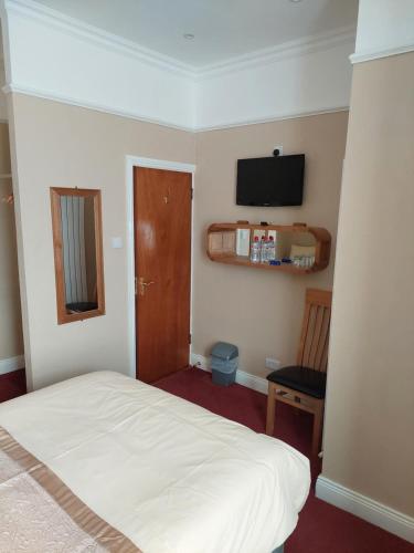 a bedroom with a bed and a television on the wall at Parkway Guesthouse in Dublin