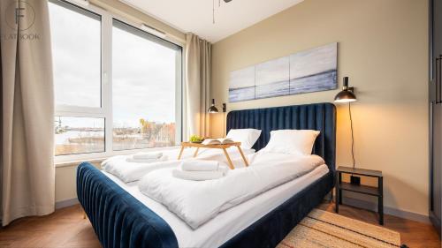 a large bed in a room with a large window at Flatbook - City Center Apartments Chlebova with Gym in Gdańsk