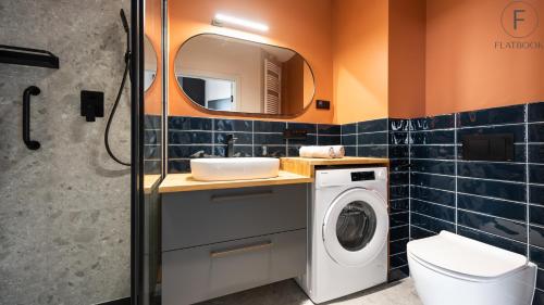 a bathroom with a sink and a washing machine at Flatbook - City Center Apartments Chlebova with Gym in Gdańsk