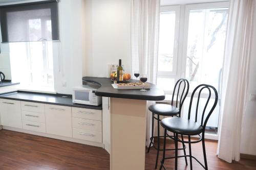 a kitchen with a counter with two chairs and a table at Apartament curat si confortabil in centru Str. Armeneasca 47 in Chişinău