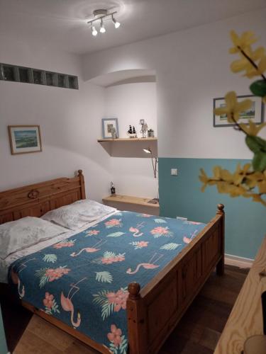 a bedroom with a bed with a blue and pink blanket at Sudety hut 2 in Podgórzyn