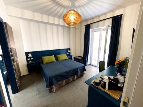 a bedroom with a blue bed and a desk at Isolotto Guest House in Porto Ercole