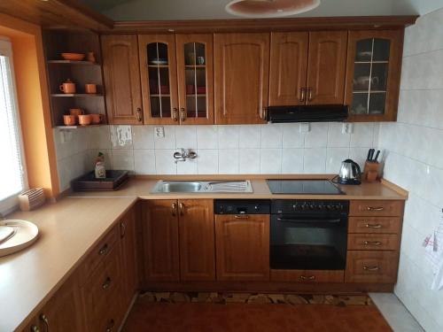 a kitchen with wooden cabinets and a stove top oven at Apartmán Jantoľák in Zuberec