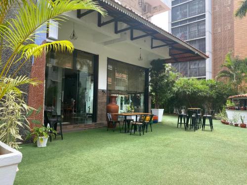 a patio with a table and chairs and a building at Ddhyana Resort in Panaji