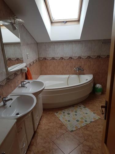 a bathroom with two sinks and a bath tub at Apartmán Jantoľák in Zuberec