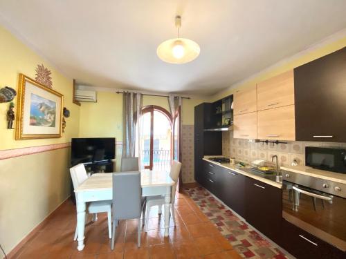 a kitchen with a white table and chairs in a room at Apartments Mikros in Giardini Naxos