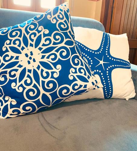 a pillow sitting on top of a blue couch at Apartments Mikros in Giardini Naxos