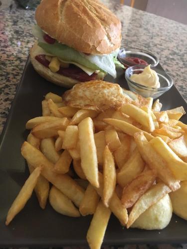 a sandwich and french fries on a black plate at da Lilia in Salute&Bellezza in Monfalcone