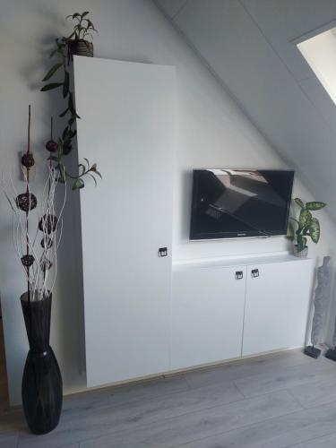 a living room with a tv on a white wall at Slapen in Dordrecht in Dordrecht