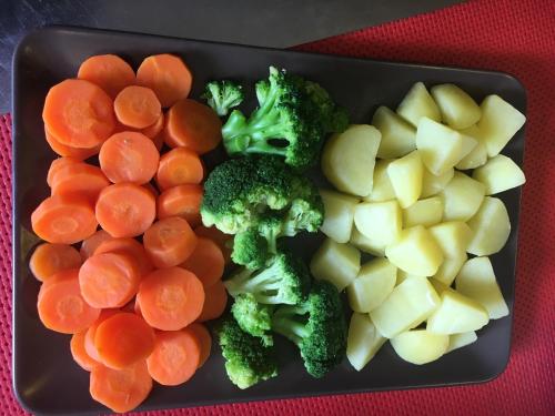 a black plate with carrots broccoli and other vegetables at da Lilia in Salute&Bellezza in Monfalcone