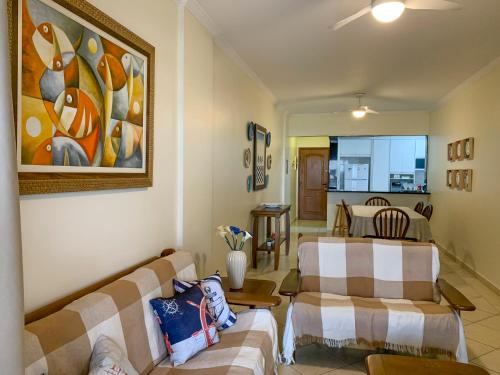 ein Wohnzimmer mit 2 Sofas und einem Tisch in der Unterkunft Apto 3 quartos, churrasqueira, vista para o mar e piscina in Praia Grande