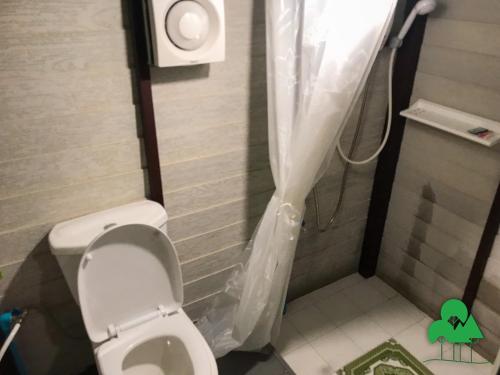 a bathroom with a toilet with a shower curtain at Baan Suanthip Homestay - Aoluek Natural Retreat in Ao Luk