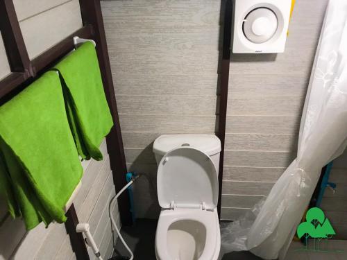 a small bathroom with a toilet and a green towel at Baan Suanthip Homestay - Aoluek Natural Retreat in Ao Luk