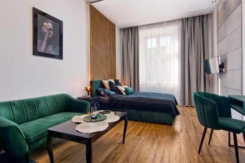 a living room with a green couch and a table at Apartament czarny z jacuzzi in Kraków