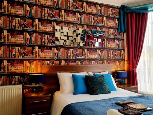 a bedroom with a bed and a wall of books at Gabrielles in Blackpool
