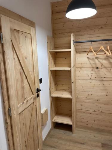 a room with a wooden door and a closet with hangers at Inovecká Chata in Trenčianske Jastrabie