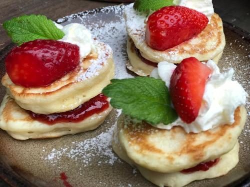 three pancakes with strawberries and whipped cream on a plate at Inovecká Chata in Trenčianske Jastrabie