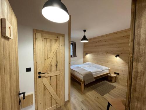 a bedroom with a bed and a wooden door at Inovecká Chata in Trenčianske Jastrabie