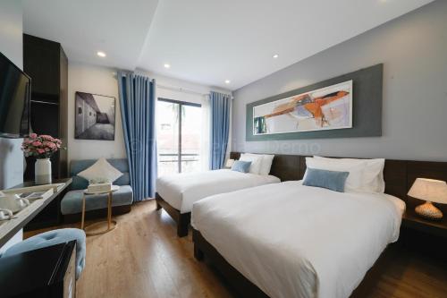 a hotel room with two beds and a sink at Lion King Hotel in Hoi An