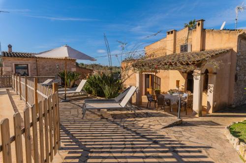 a patio with a table and chairs and a building at Finca Cavea in Caʼs Concos