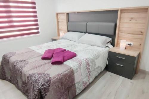 um quarto com uma cama com toalhas roxas em - LUJO - Parking, Maquina Arcade, Wifi y Netflix em Oviedo