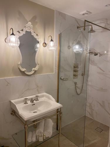 a bathroom with a sink and a shower with a mirror at Abbey Green Farm in Wem
