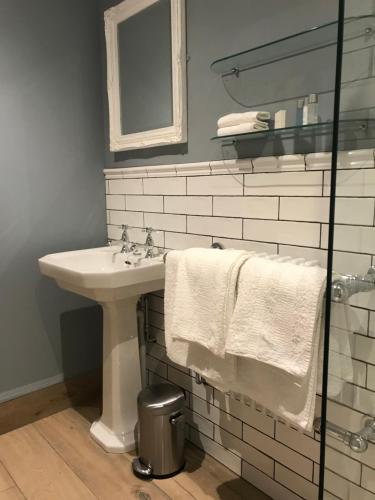 a bathroom with a sink and a mirror and towels at Abbey Green Farm in Wem