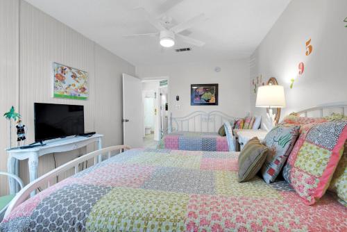 a bedroom with two beds and a flat screen tv at Gulf Crest #7 in Destin