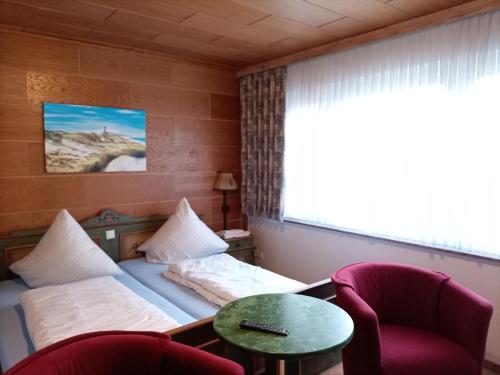 um quarto de hotel com uma cama e duas cadeiras e uma mesa em Ferienwohnung Ulmenstraße em Bremerhaven