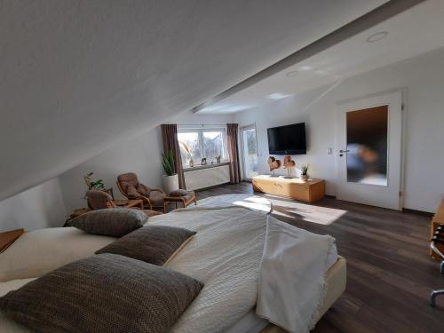 a bedroom with a large bed and a living room at Pflaumers Ferienwohnung in Eppingen