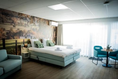 1 dormitorio con 1 cama y una pintura en la pared en Hotel La Source Epen, en Epen