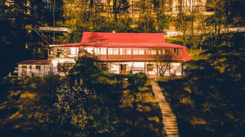 a house with a red roof on a hill at Seclude Shimla, Taraview in Shimla