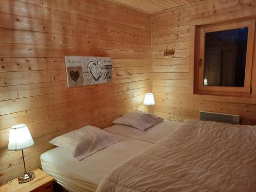 a bedroom with a bed in a wooden wall at Le chalet de la Chouille in Xonrupt-Longemer