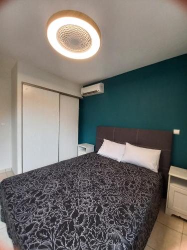 a bedroom with a large bed and a blue wall at Bel Appartement avec terrasse proche des plages in Saint-Gilles les Bains