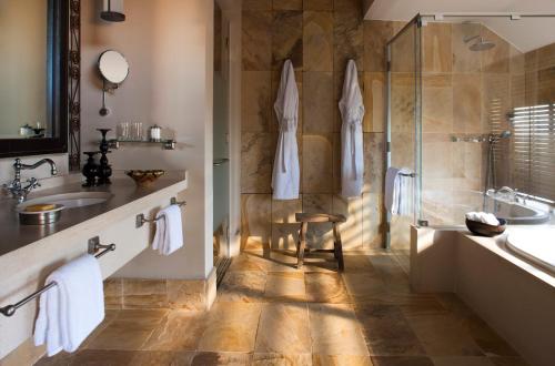 een badkamer met een bad, een wastafel en een douche bij Four Seasons Safari Lodge Serengeti in Banagi