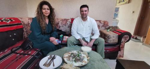 a man and a woman sitting on a couch at Petra View Flat in Wadi Musa