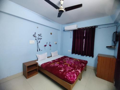 a bedroom with a bed and a ceiling fan at Matri Hotel & Banquets in Patna