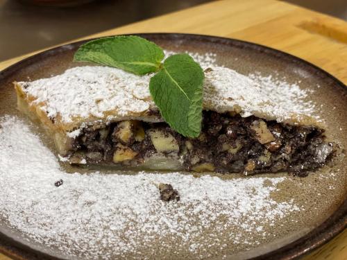 a piece of pie with a green leaf on a plate at Inovecká Chata in Trenčianske Jastrabie