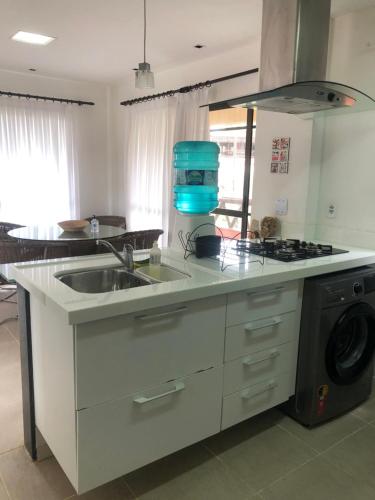 a kitchen with a sink and a stove at Beach front apartment in Dream Village Cumbuco, Ceara in Cumbuco