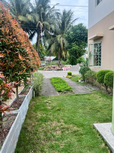 a garden in front of a house with palm trees at Beach Resorts walking distance to the Town House in Davao City