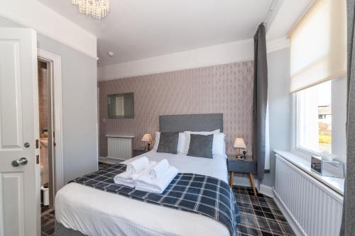 a bedroom with a bed with two towels on it at The Coppice - including off-site health club in Windermere