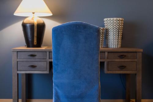 a blue chair next to a desk with a lamp at Der Unterschwarzachhof in Saalbach Hinterglemm