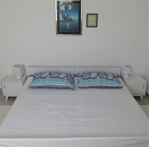 a white bed with two pillows in a bedroom at Apartments Biba & Lucy in Ražanac