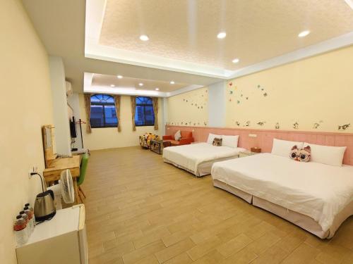 una camera d'albergo con due letti e una tv di Cat Mia Hostel a Città di Hualien