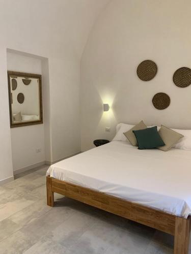 a bedroom with a large white bed and a mirror at Dimora delle Tonnare in Favignana