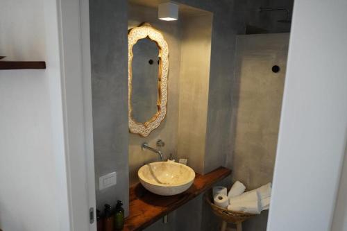 a bathroom with a bowl sink and a mirror at Dimora delle Tonnare in Favignana
