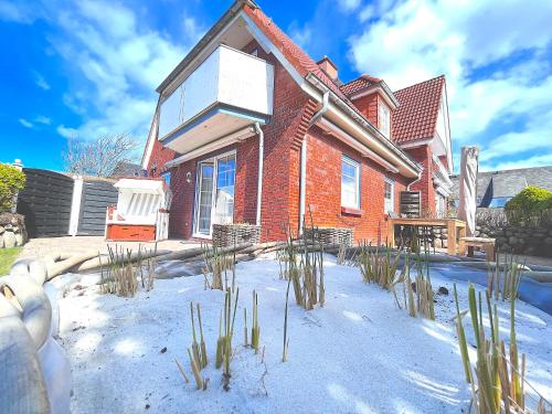 a red brick house with snow in front of it at To Huus - im Süden von Westerland in Westerland (Sylt)